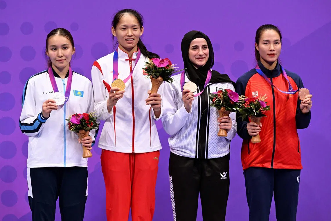 Palestinian karateka Hala Alqadi (second from right) on the Asian Games podium with Kazakhstan's Laura Alikul (left), China's Li Qiaoqiao and Vietnam's Thi Huong Dinh.