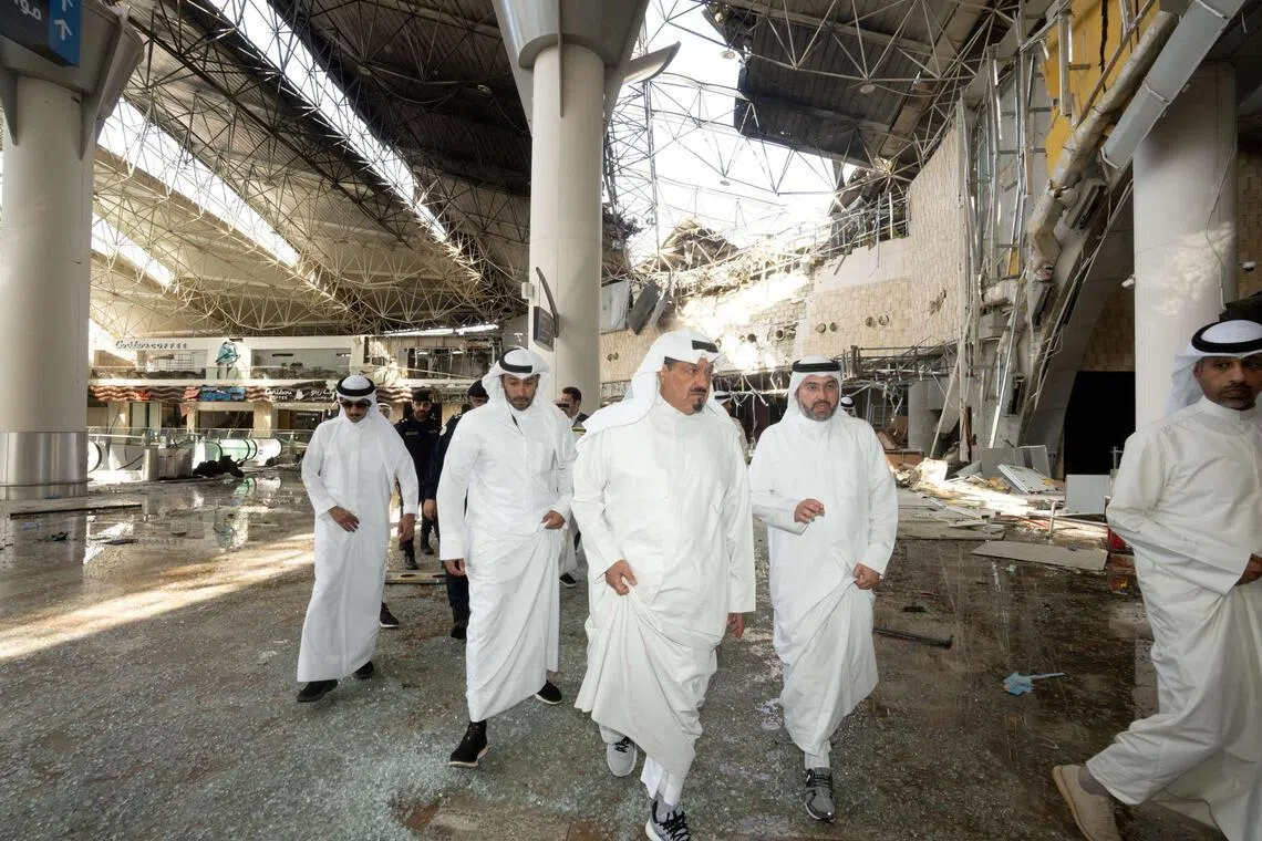 Kuwaiti officials inspecting damage inside a terminal at Kuwait International Airport following a drone and missile attack on June 3.