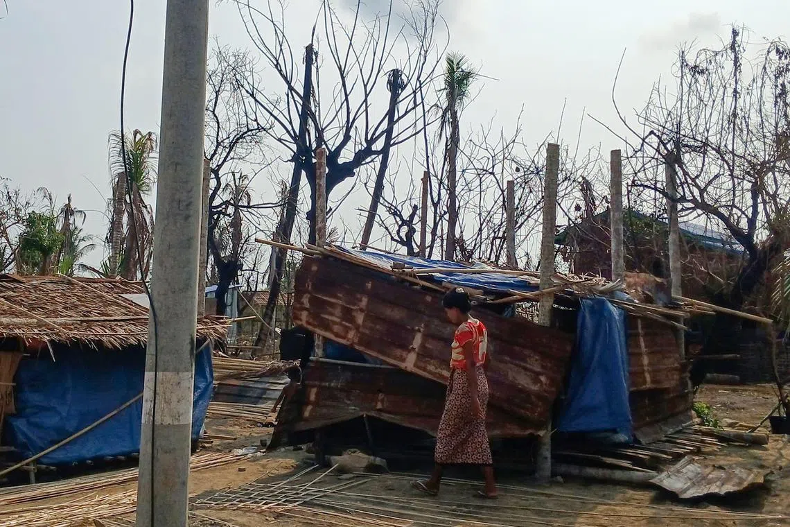 A woman walking past her temporary house following fighting between Myanmar's military and the Arakan Army (AA) ethnic minority armed group in a village in Minbya Township in western Rakhine State on May 21.