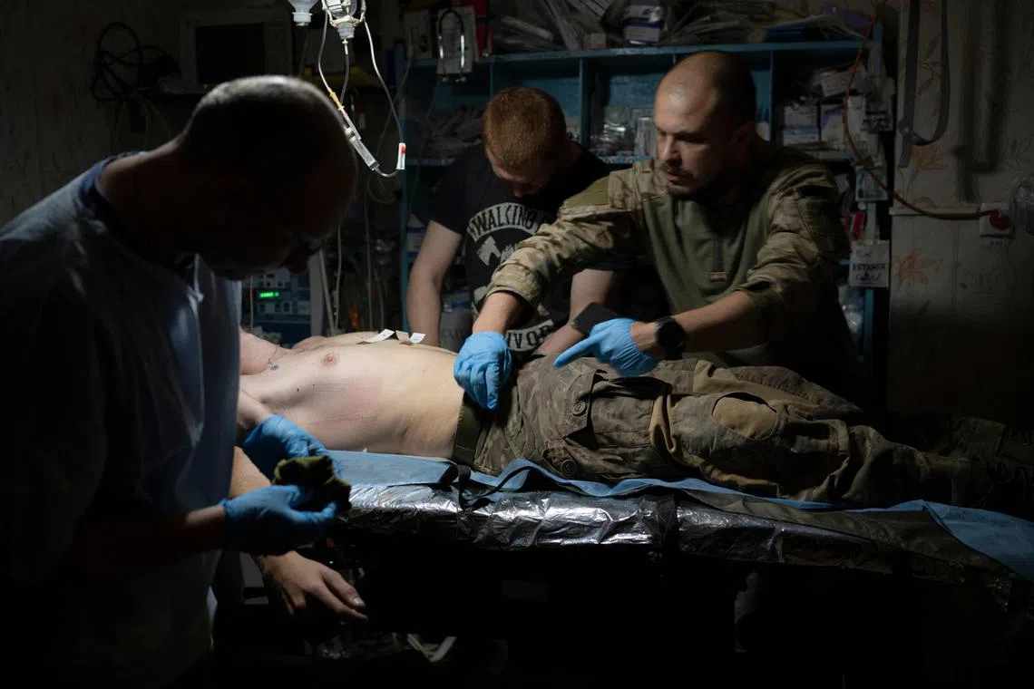 Ukrainian medics from the 5th assault brigade treat wounded Ukrainian servicemen at a stabilisation point.