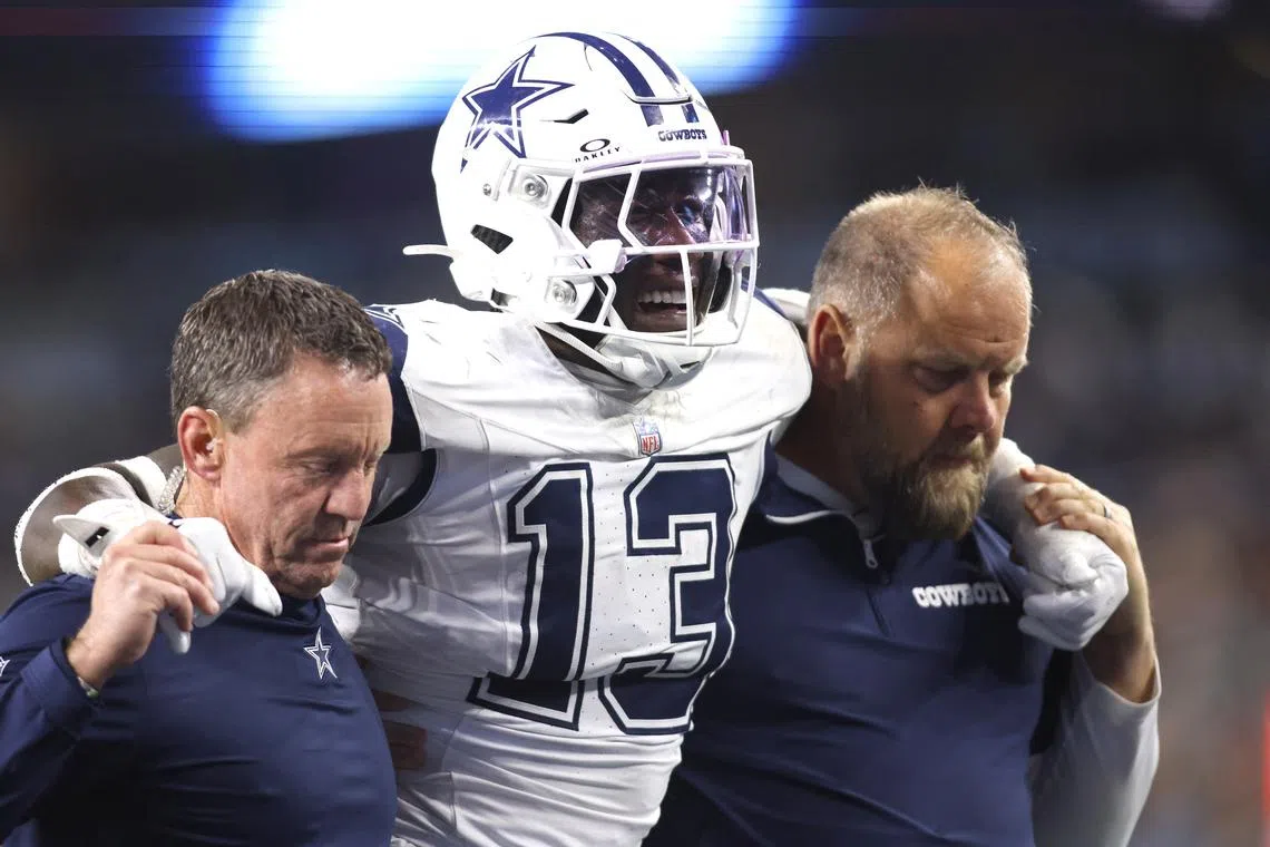 Dec 9, 2024; Arlington, Texas, USA; Dallas Cowboys linebacker DeMarvion Overshown (13) is helped off the field after an injury in the second half against the Cincinnati Bengals at AT&T Stadium. Mandatory Credit: Tim Heitman-Imagn Images