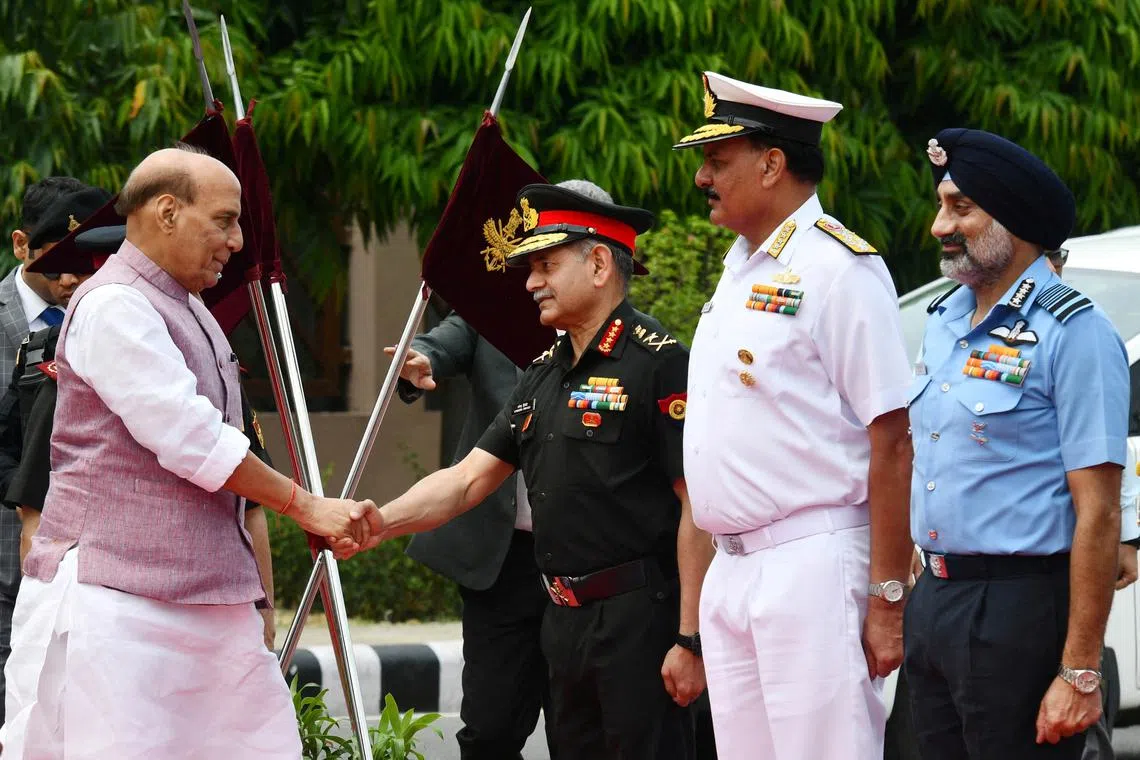 FILE PHOTO: India's Defence Minister Rajnath Singh shakes hands with Army Chief Upendra Dwivedi as Navy Chief Admiral Dinesh Kumar Tripathi and Air Chief Marshal Amar Preet Singh look on before the ceremonial reception of Japan's defence minister in New Delhi, India, May 5, 2025. REUTERS/Stringer/File Photo