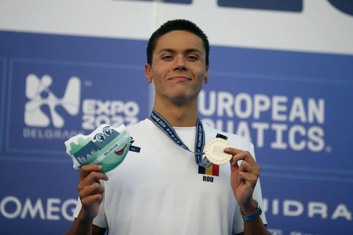 Romania's David Popovici celebrates on the podium after winning the 100m free at the European Championships.