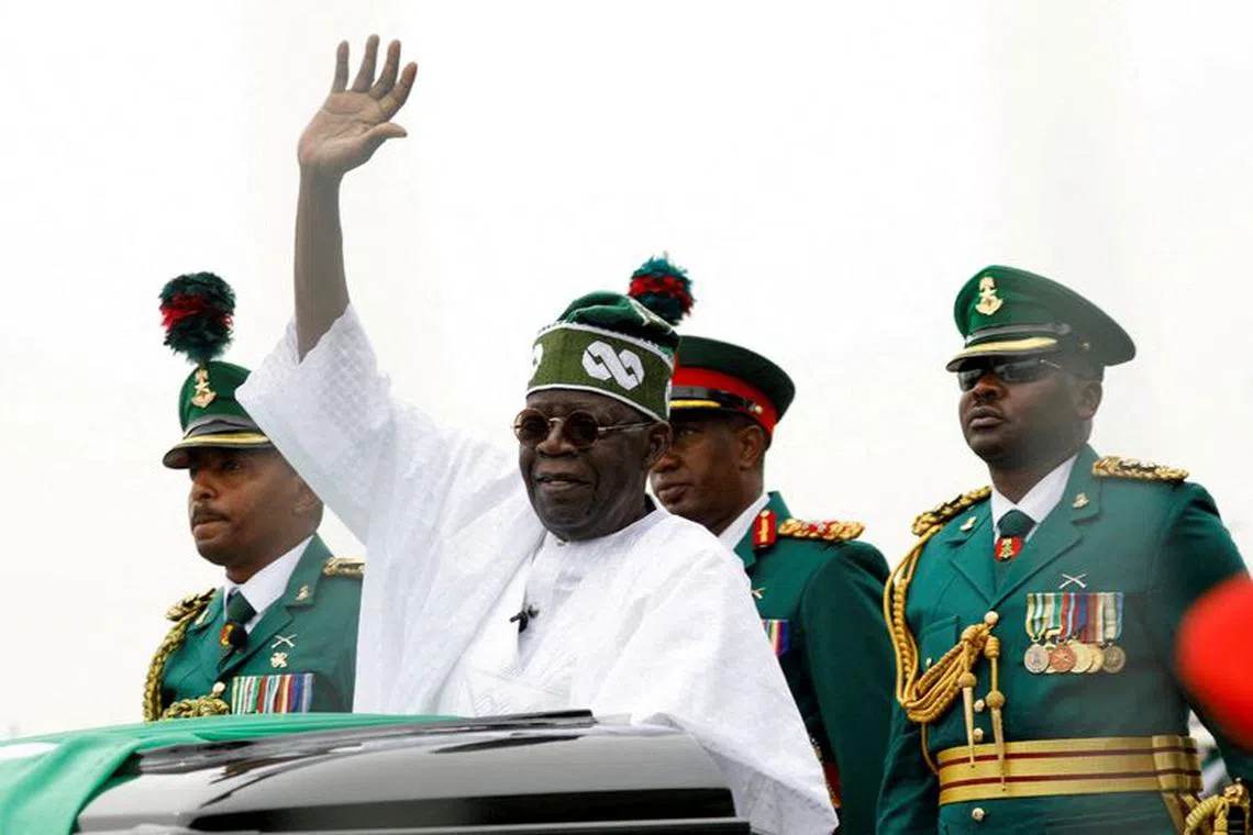 FILE PHOTO: Nigerian President Bola Tinubu waves at a crowd, during his swearing-in ceremony in Abuja, Nigeria May 29, 2023. REUTERS/Temilade Adelaja/File Photo