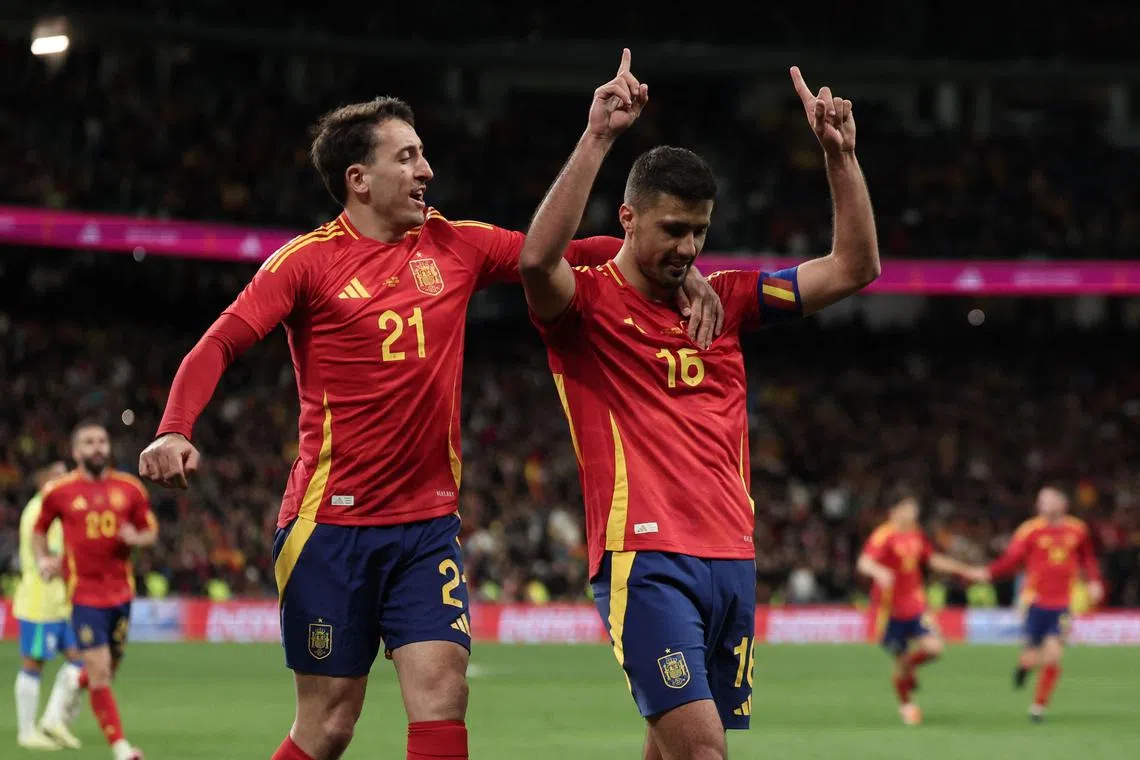 Spain midfielder Rodri celebrates with Mikel Oyarzabal (left) after scoring against Brazil in a friendly match in March 2024.