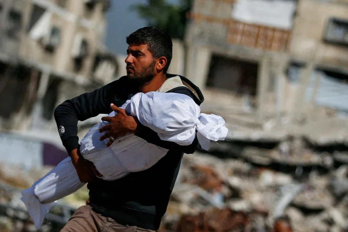 A Palestinian man carries the body of a child killed in Israeli strikes,‏ in Jabalia, in the northern Gaza Strip May 16, 2025. REUTERS/Mahmoud Issa