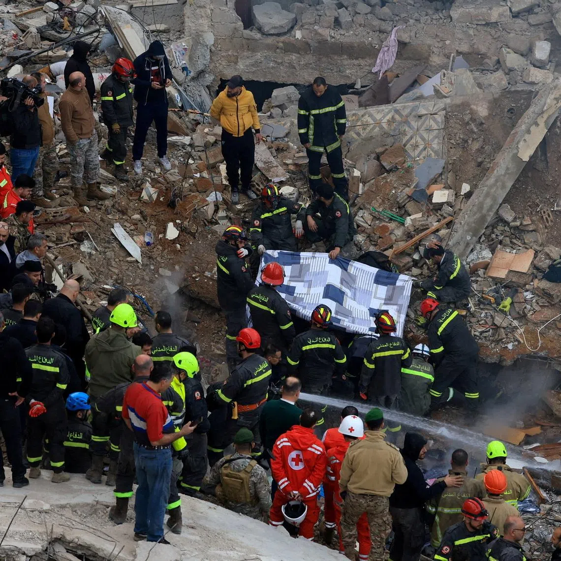 Rescue workers remove a body from under the rubble after a residential building collapsed in Tripoli, Lebanon, February 9, 2026. REUTERS/Mohammed Azakir