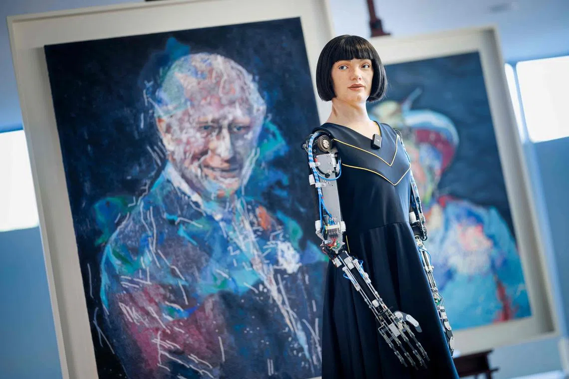Ultra-realistic humanoid artist robot Ai-Da looks on in front of paintings of Britain's King Charles III and Queen Elizabeth II, displayed on the sidelines of the AI for Good Global Summit organised by International Telecommunication Union (ITU) in Geneva, on July 9, 2025. 