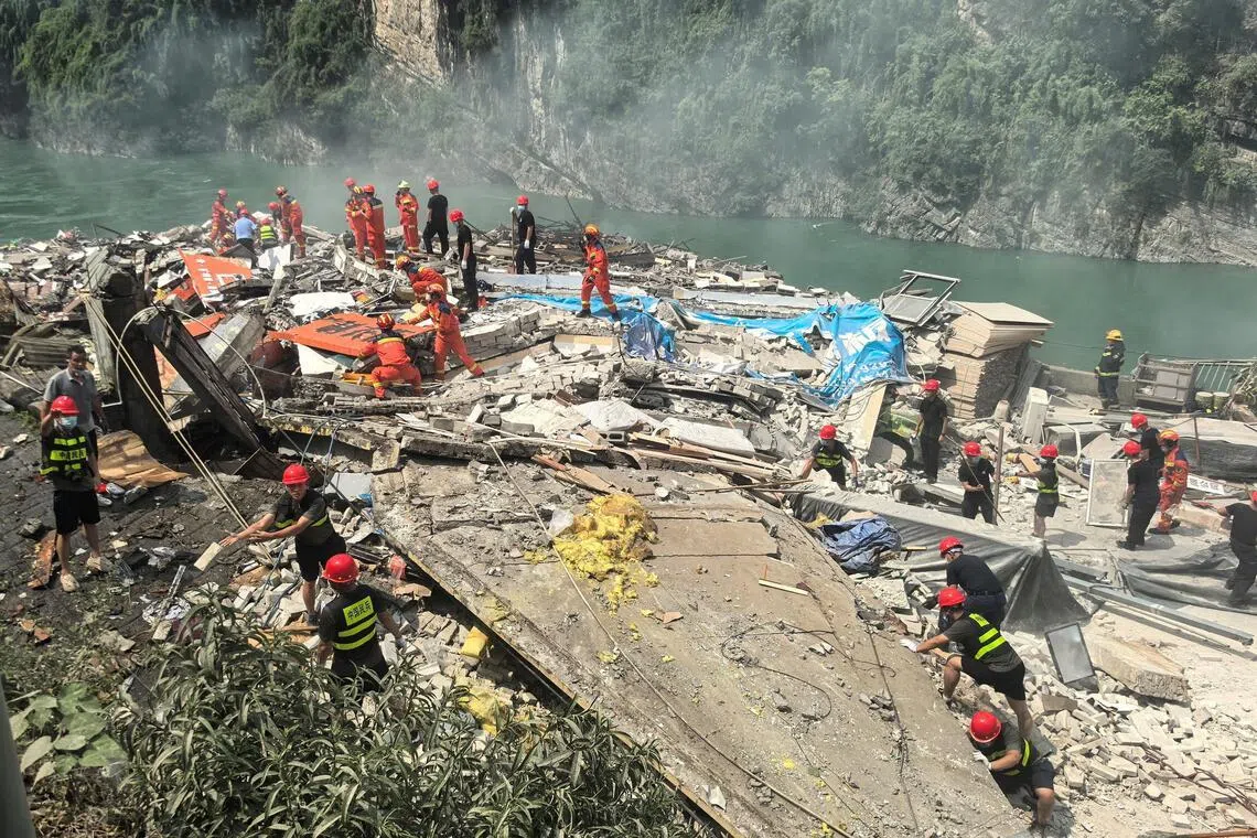 Rescue workers search for survivors at the site of the landslide in Chongqing on July 17.