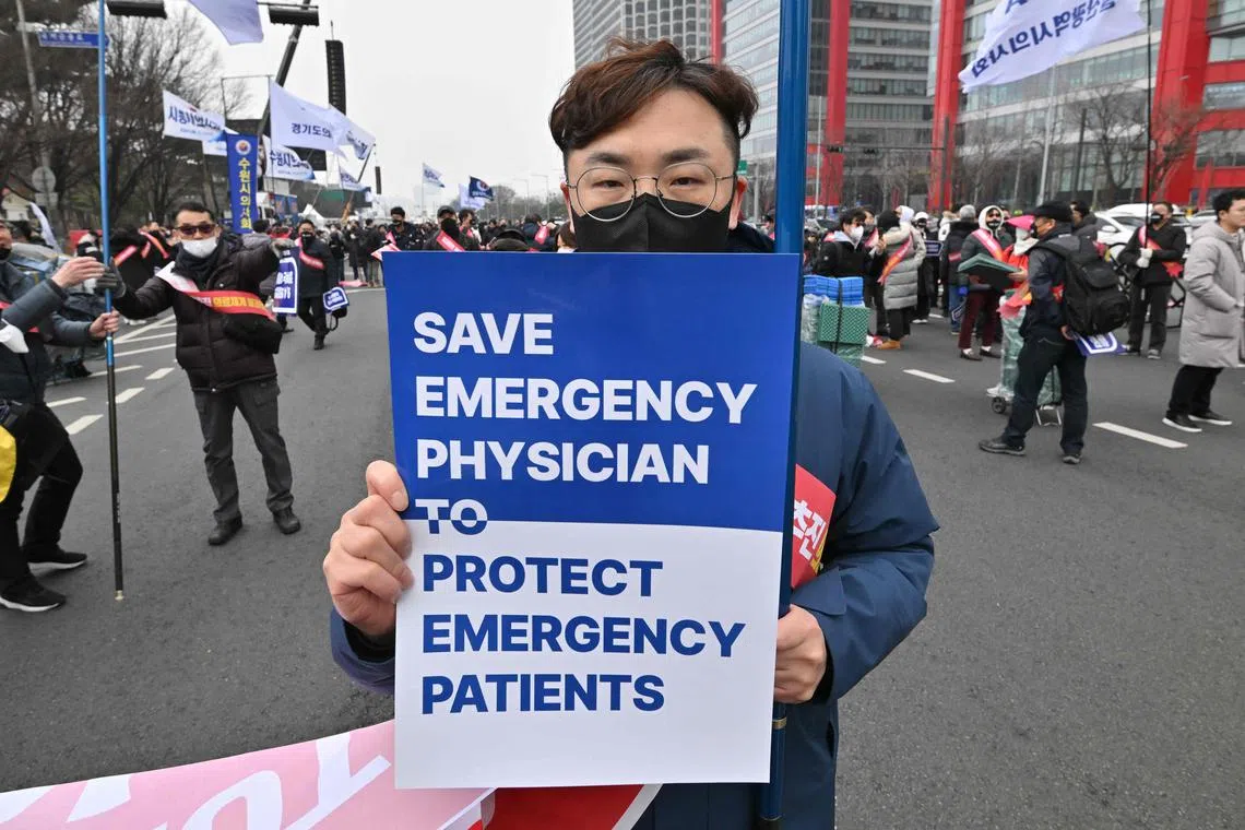 A doctor holds a placard during a rally against the government’s plan to raise the annual enrolment quota at medical schools, in Seoul on March 3, 2024. 