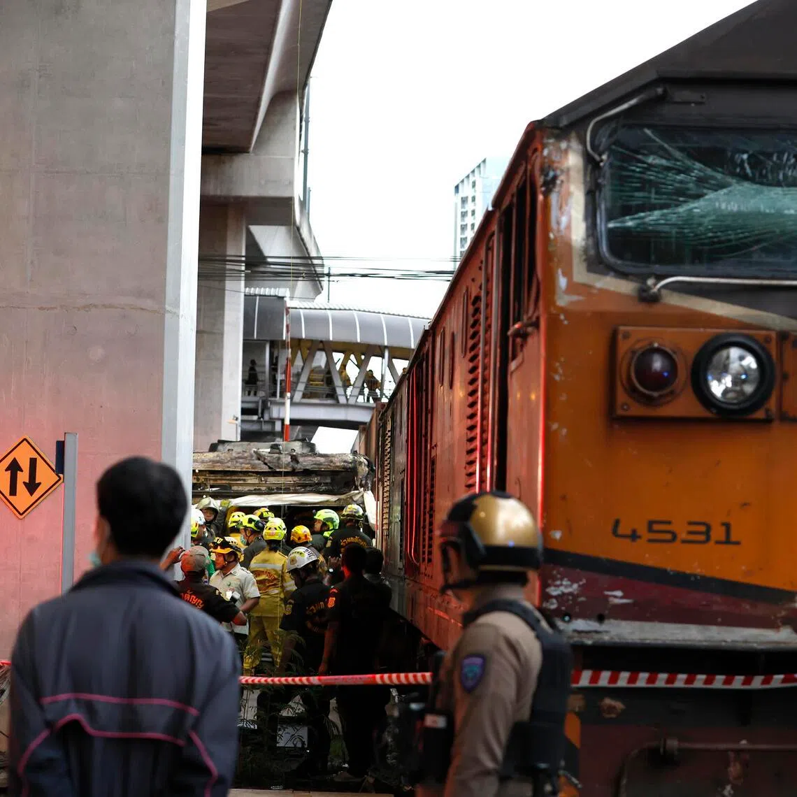 Thai rescue workers search for victims following a collision between a freight train and a bus at the Airport Rail Link's Makkasan station in Bangkok, Thailand, on May 16.