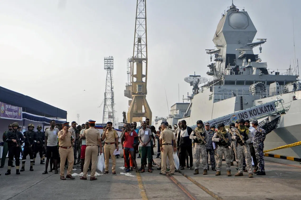 Indian soldiers stand guard next to captured Somali pirates after they were brought in for prosecution by the Indian Navy, at the Naval Dockyard in Mumbai, India, March 23, 2024. REUTERS/Hemanshi Kamani