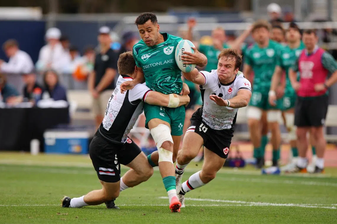 Ireland's Conor Phillips being tackled by Canada's Morgan di Nardo and Kalin Sager in the HSBC Sevens World Championship at Dignity Health Sports Park in Los Angeles, California on May 3, 2025.