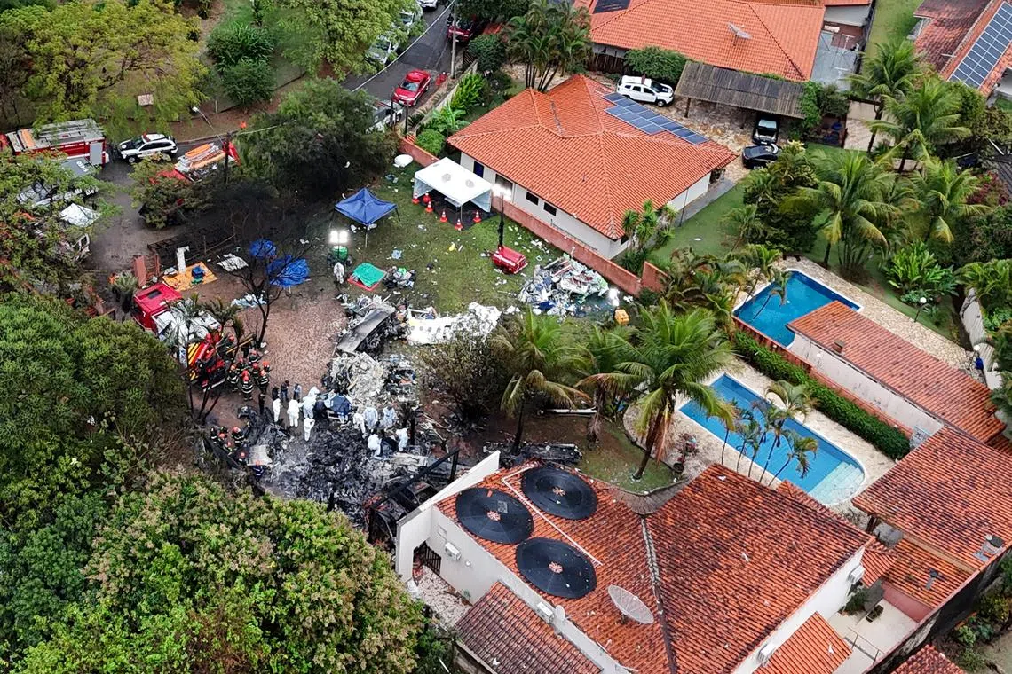 FILE PHOTO: A drone view shows people working at the site of a plane crash in Vinhedo, Sao Paulo, Brazil, August 10, 2024. REUTERS/Carla Carniel/File Photo