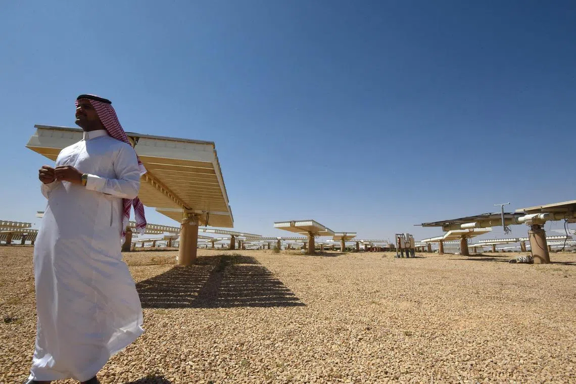 (FILES) A Saudi man stands at a solar plant in Uyayna, north of Riyadh, on March 29, 2018. After riding a fossil-fuel boom for decades, Arab Gulf states are eyeing "green" hydrogen, extracted from water using renewable energy such as wind, solar and hydropower, as they try to transition their economies and ease the climate crisis at a stroke. (Photo by FAYEZ NURELDINE / AFP)