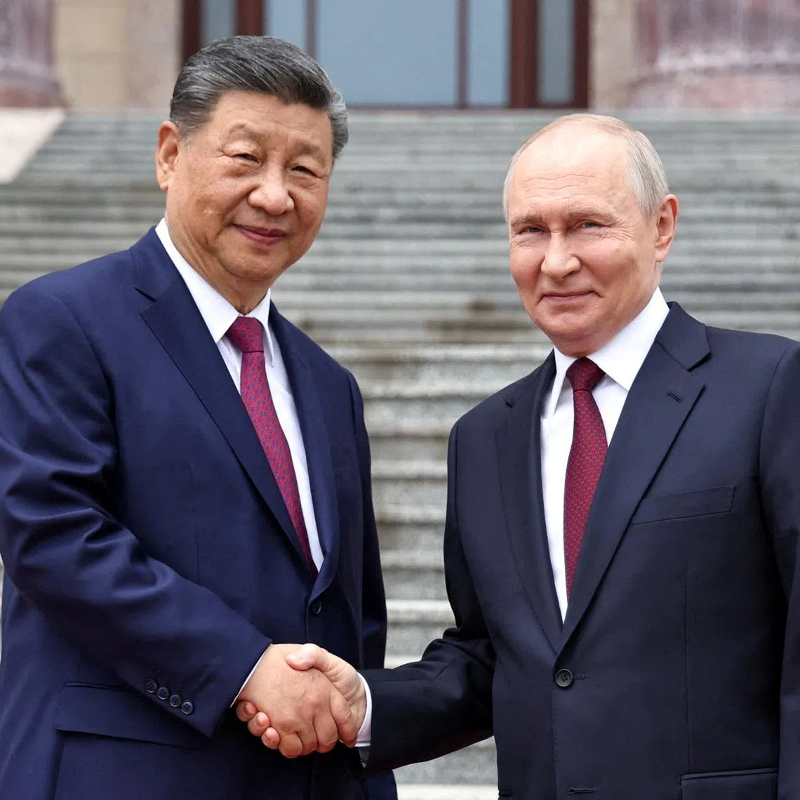 Russian President Vladimir Putin shakes hands with Chinese President Xi Jinping during a welcoming ceremony at the Great Hall of the People in Beijing, China, on May 20.
