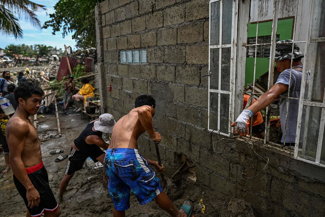 Residents cleaning up their damaged houses in the aftermath of Typhoon Kalmaegi in Talisay, Cebu, Philippines, on Nov 5, 2025. 