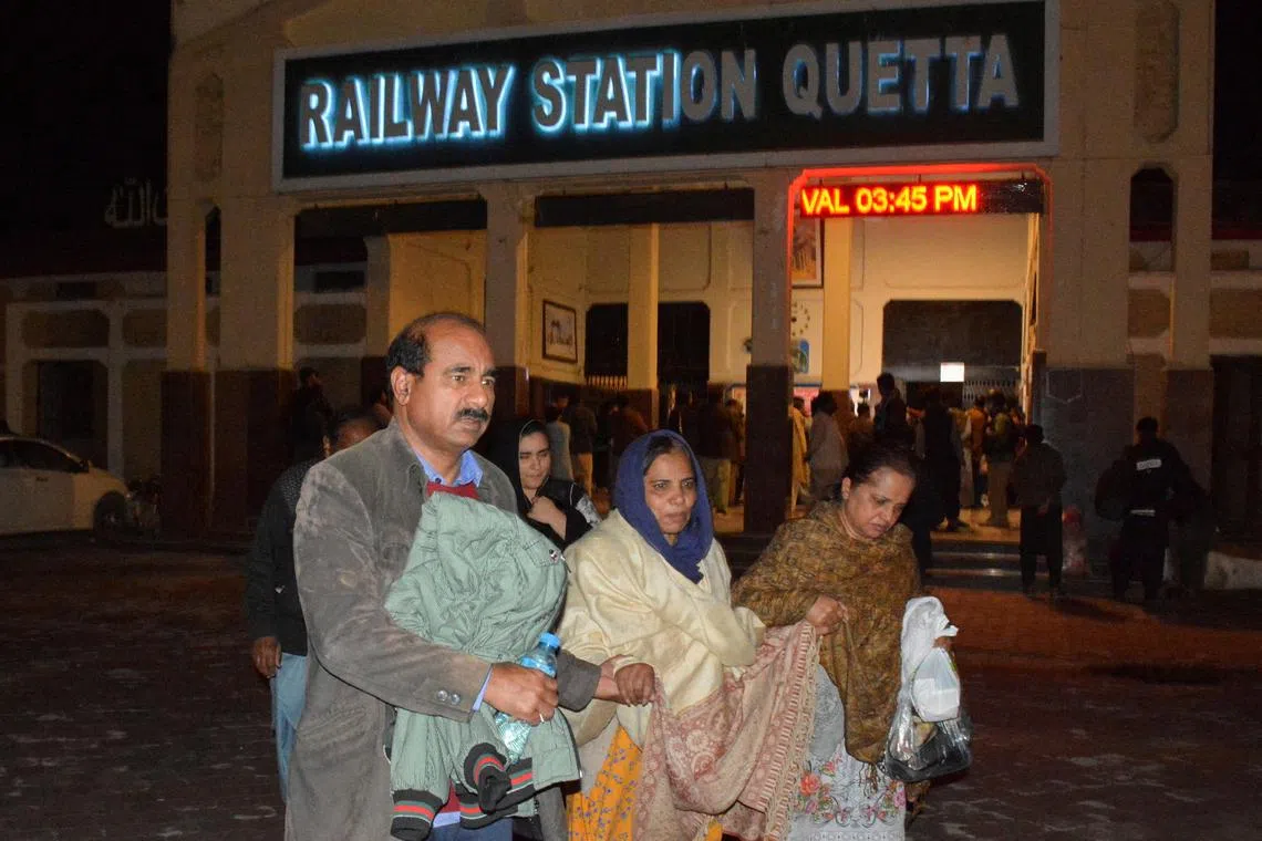 Passengers who were rescued from a train after it was attacked by separatist militants, walk with their belongings at the Railway Station in Quetta, Balochistan, Pakistan, March 12, 2025. REUTERS/Stringer