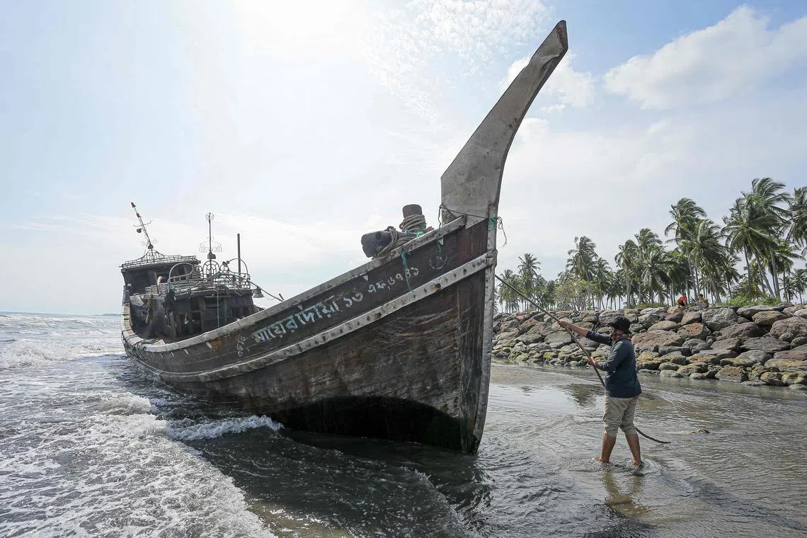 A villager pulls a rope on a wooden boat used by Rohingya people in Pidie, in Indonesia's Aceh province, on Dec 27, 2022. 