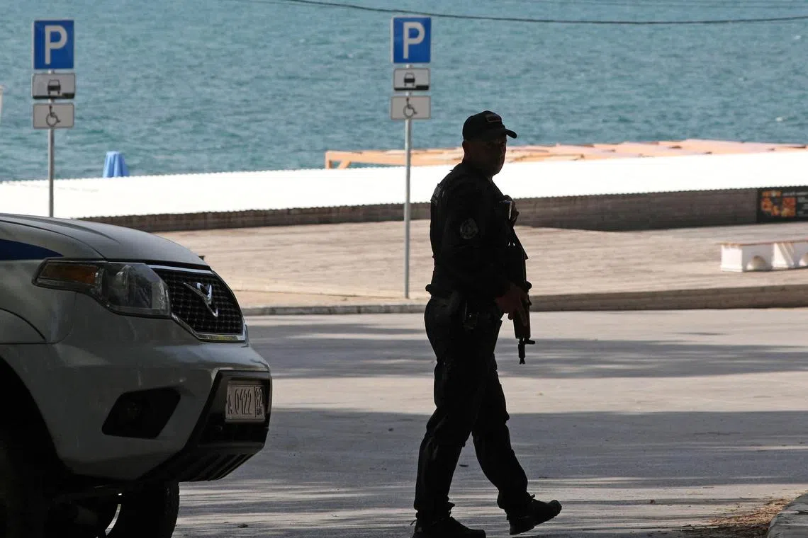 A police officer standing guard near a beach in Sevastopol, in the Russian-occupied Ukrainian peninsula of Crimea.