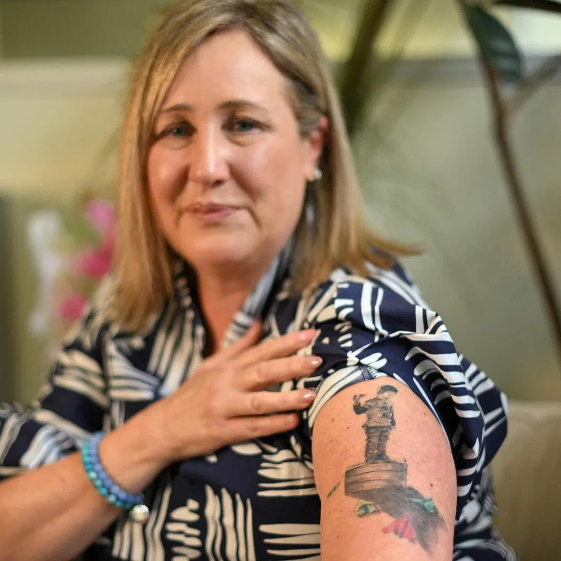 Ms Mia Bannister shows a tattoo dedicated to her son, Ollie, who took his own life after being bullied online.