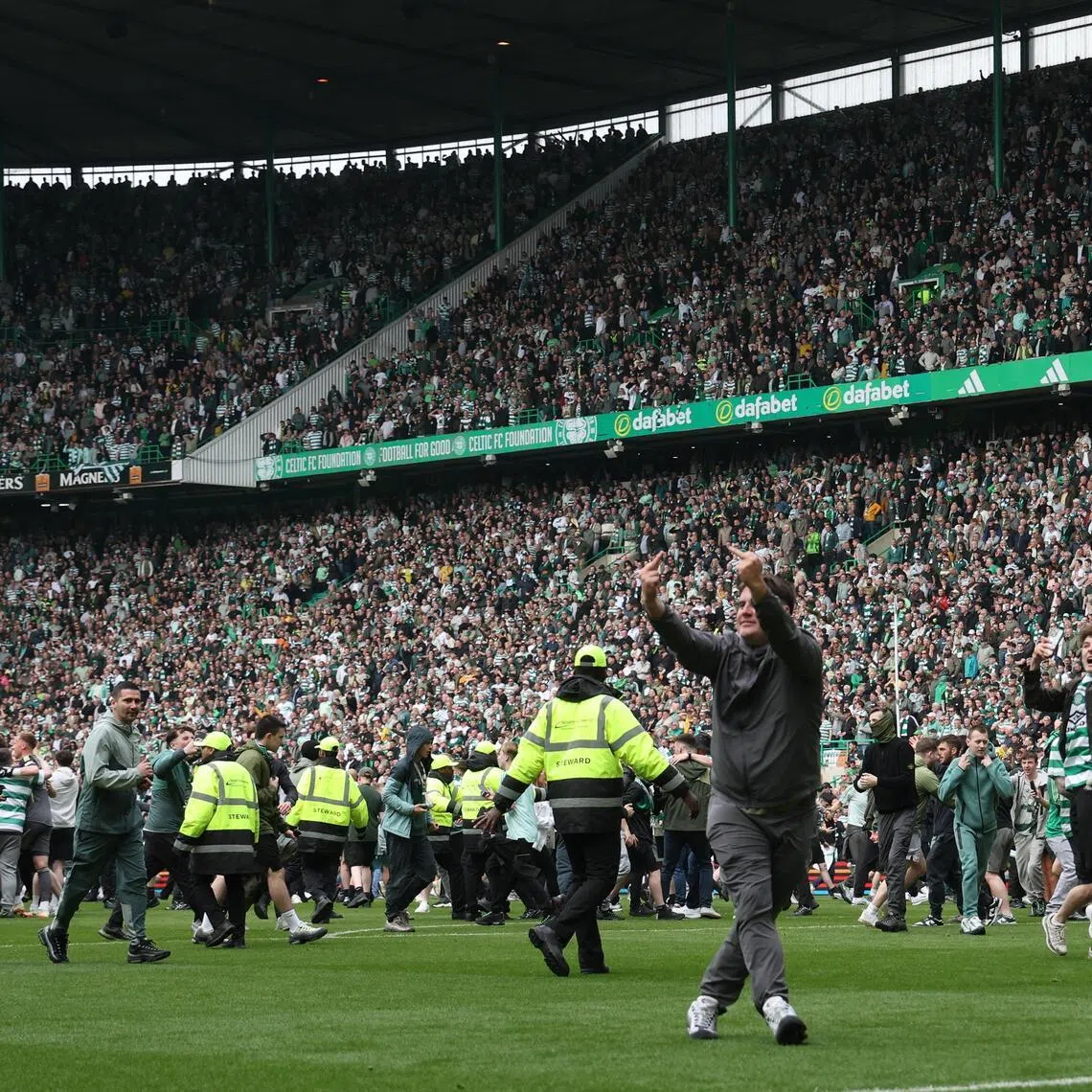 Celtic fans invade the pitch after Callum Osmand scores their third goal in the 3-1 win over Heart of Midlothian to secure the Scottish Premiership at Celtic Park in Glasgow on May 16, 2026.