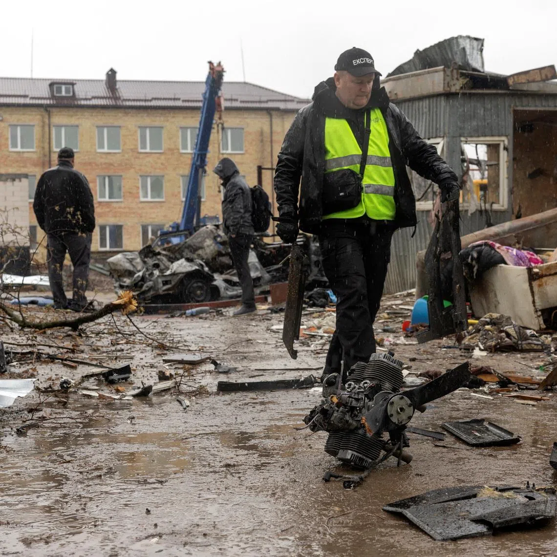 An investigator collects debris of a Russian drone at the impact site in a residential neighborhood, amid Russia's attack on Ukraine, in Vyshneve, outside Kyiv, Ukraine, April 3, 2026. REUTERS/Thomas Peter