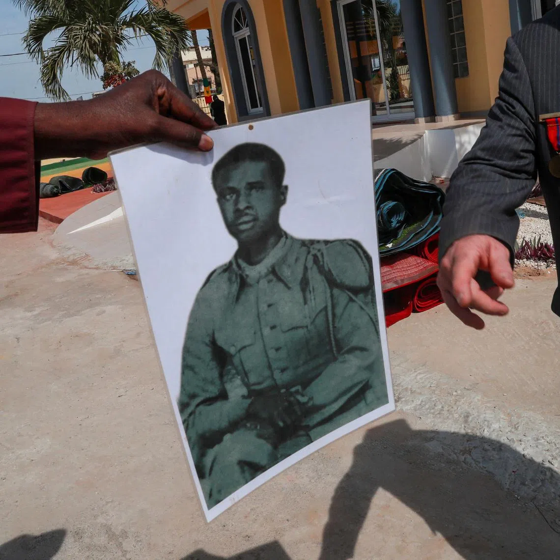 A family member shows a photograph of his relative that was killed during the Thiaroye massacre as Senegal commemorates the 80th anniversary of a massacre of African soldiers who fought for France during WW2, and were gunned down by French troops in 1944 for demanding fair treatment and pay in Thiaroye, Senegal December 1, 2024. REUTERS/Amira Karaoud