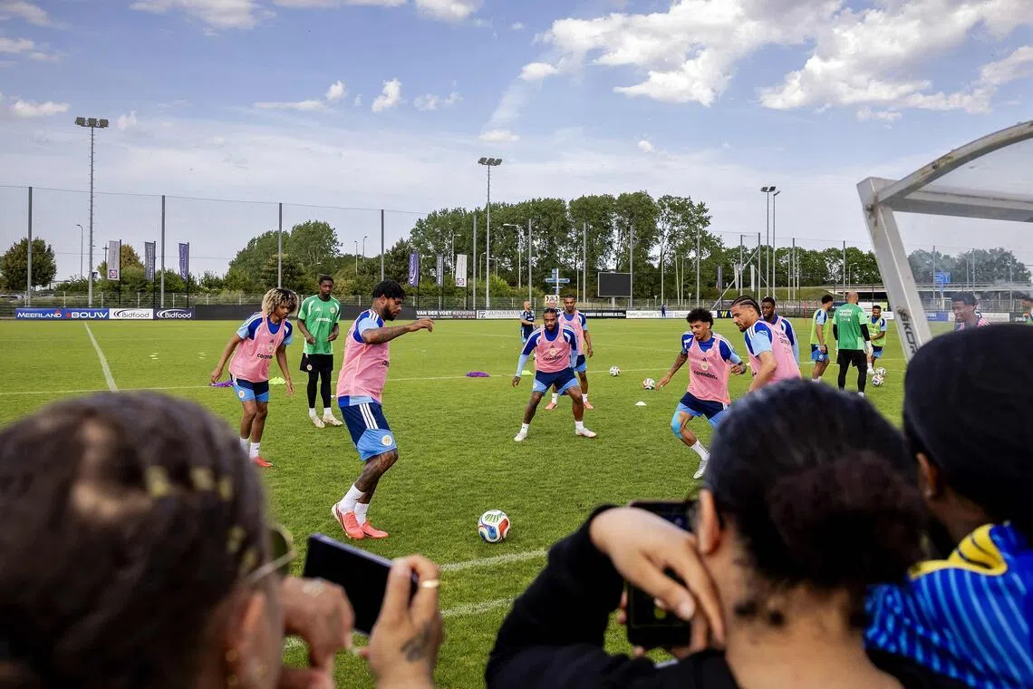 Supporters watch Curacao's players practising during a training session.