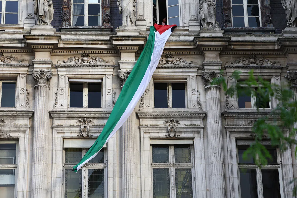 A Palestinian flag, unfurled by activists, hangs over Paris City Hall in Paris, France, on Sept 22.