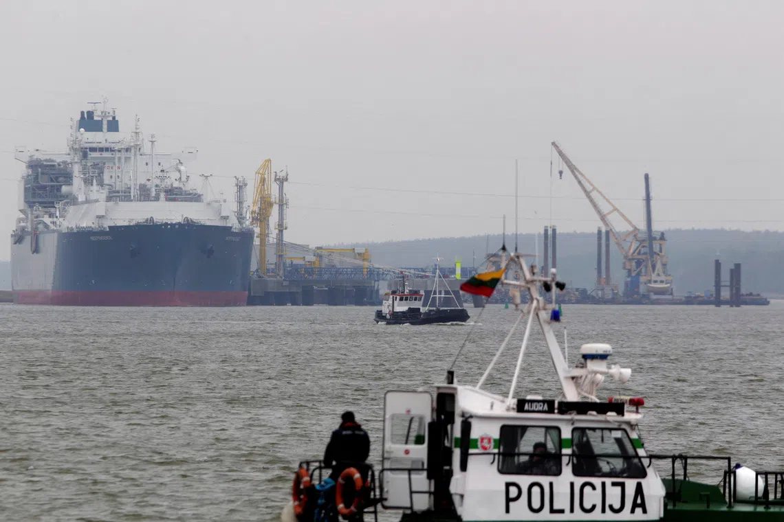 FILE PHOTO: A police boat is seen in the foreground of the floating storage regasification unit \"Independence\" on October 27, 2014, one of the key infrastructure objects in Lithuania now guarded by military due to fears of a Russian false-flag attack. REUTERS/Ints Kalnins/File Photo