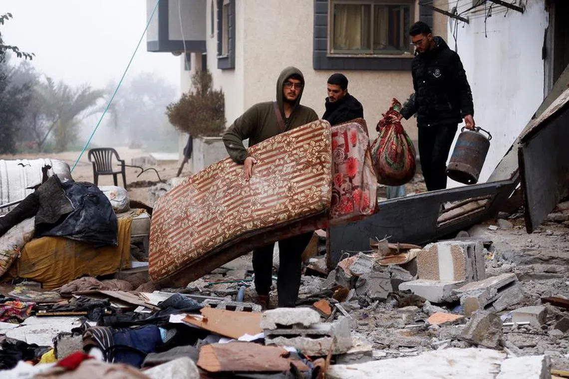 Palestinians carry belongings at the site of an Israeli strike on a house, amid the ongoing conflict between Israel and the Palestinian Islamist group Hamas, in Rafah in the southern Gaza Strip, February 9, 2024. REUTERS/Ibraheem Abu Mustafa