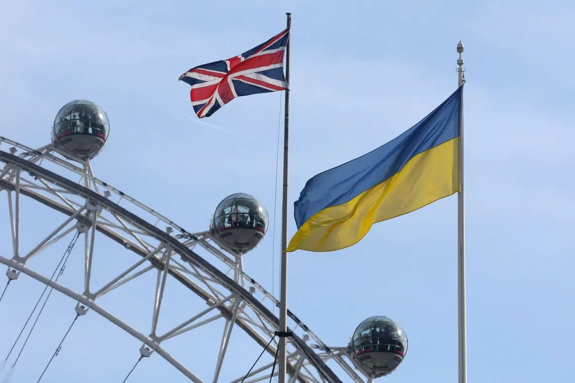 FILE PHOTO: Ukraine flag and British Union flag fly from British government buildings as people ride on the London Eye wheel attraction, in London, Britain, February 23, 2024. REUTERS/Toby Melville/ File Photo
