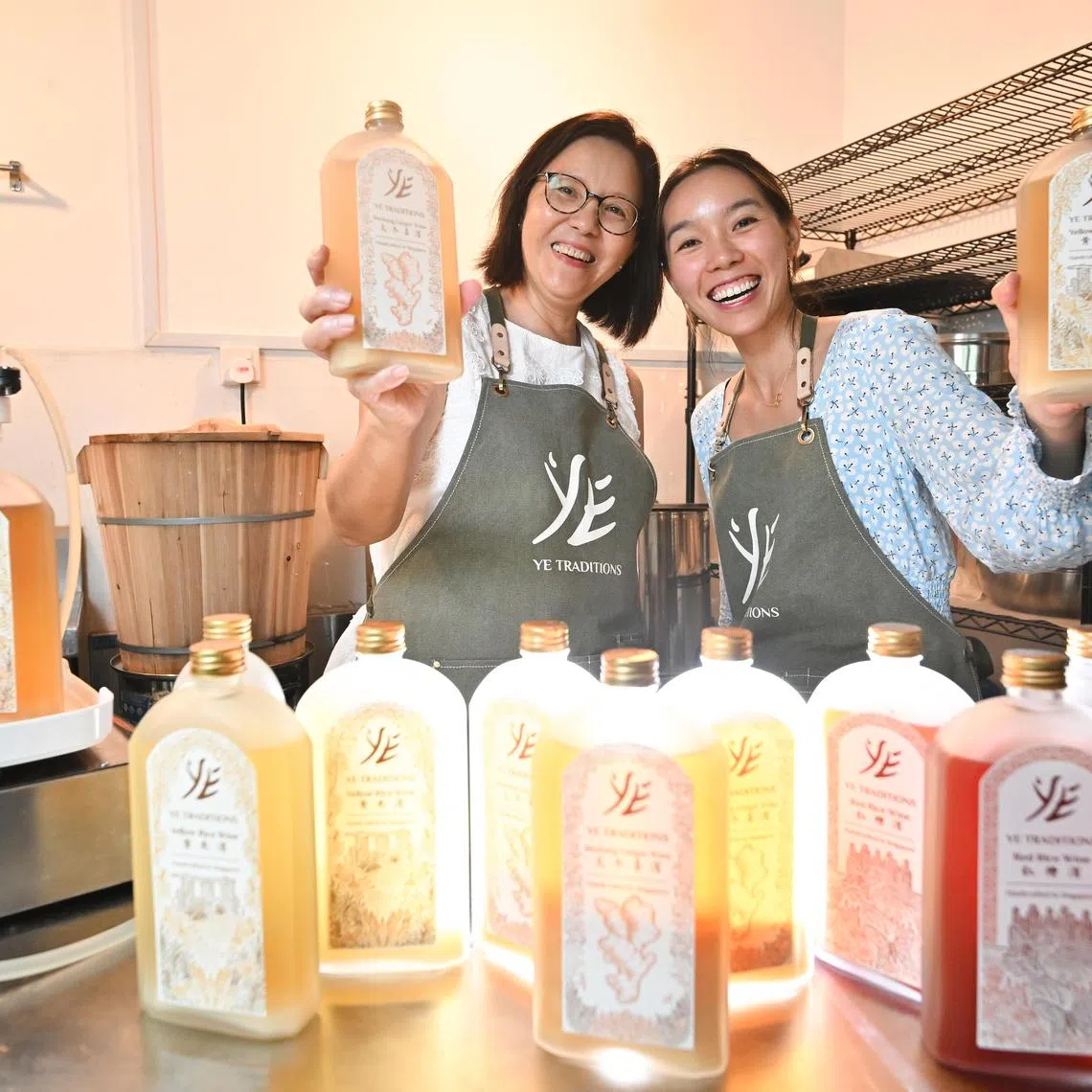ST20250505-202528400932-Lim Yaohui-Venessa Lee-vlmum/

Madam Yap Joo Eng, 62, with her daughter Ms Yap Jinyen, 32, both co-founders of Ye Traditions, holding bottles of yellow rice wine and bentong ginger wine inside their brewery on May 5, 2025.  

Part of a Mother's Day 2025 story package: Mums with impressive, later- life achievements as they changed their life direction. Jinyen and her mother are co-founders of Ye Traditions, which handcrafts heritage rice wines. Mum, now in her early 60s, talks about her late-blooming 2nd career in crafting heritage rice wines after retiring.

(ST PHOTO: LIM YAOHUI)
