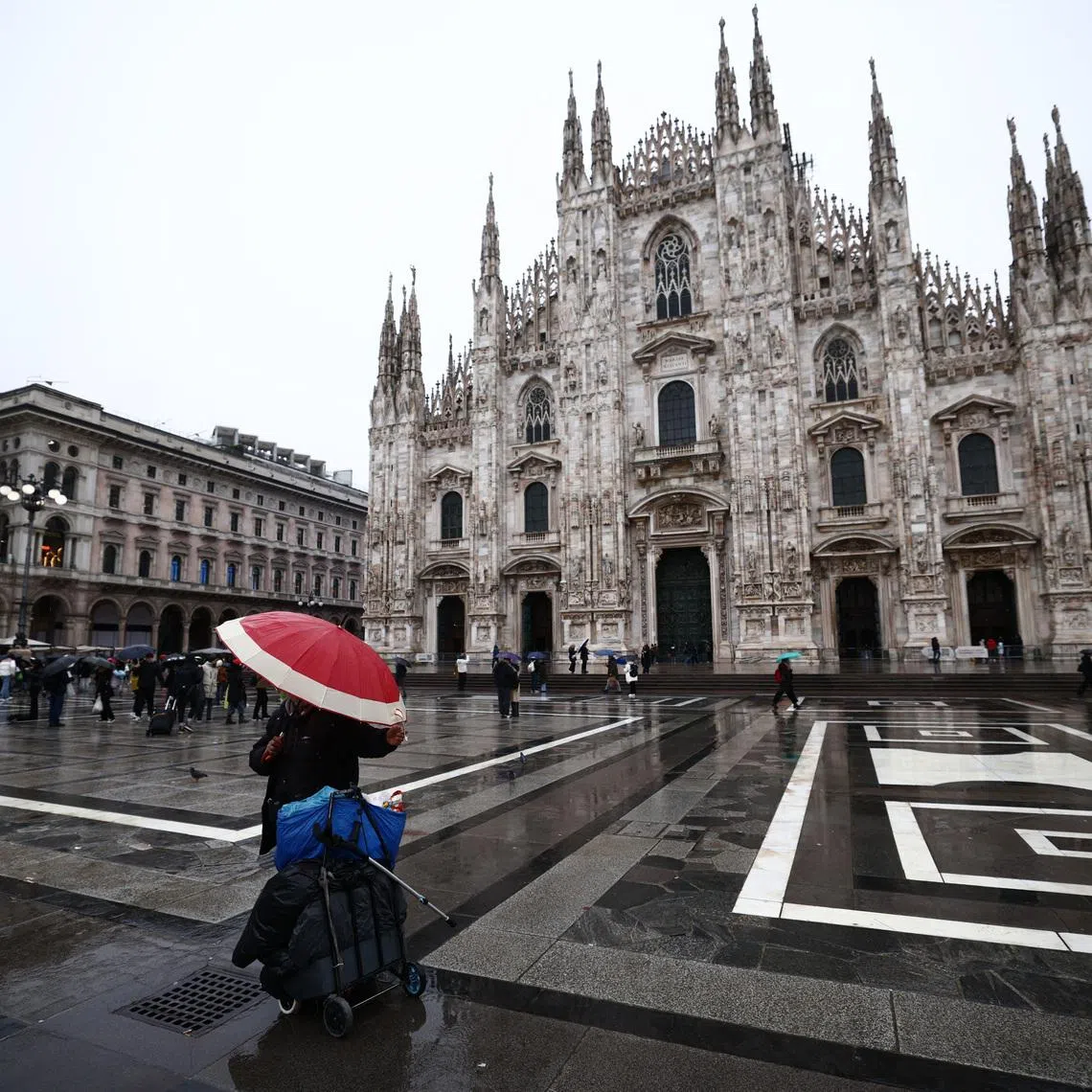 Milano Cortina 2026 Winter Olympics - Preview - Milan, Italy - February 4, 2026 A person with an umbrella outside the Duomo di Milano REUTERS/Guglielmo Mangiapane