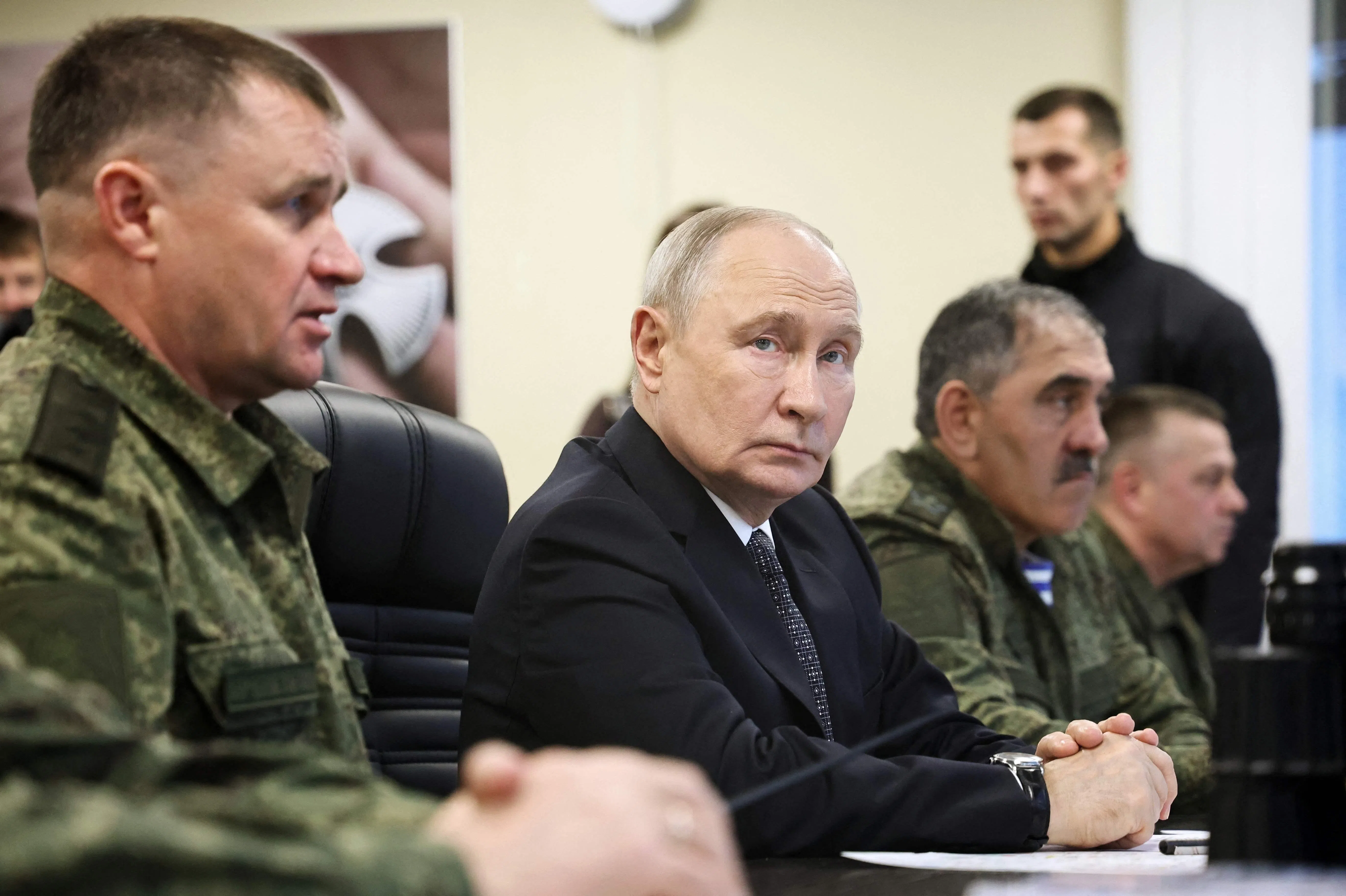 In this pool photograph distributed by the Russian state agency Sputnik, Russia's President Vladimir Putin (C) looks on as he visits an observation post during the "Center-2026" strategic command-and-staff exercise at the Chebarkulsky training ground in Chelyabinsk Region on October 2, 2026. (Photo by Alexander KAZAKOV / POOL / AFP)