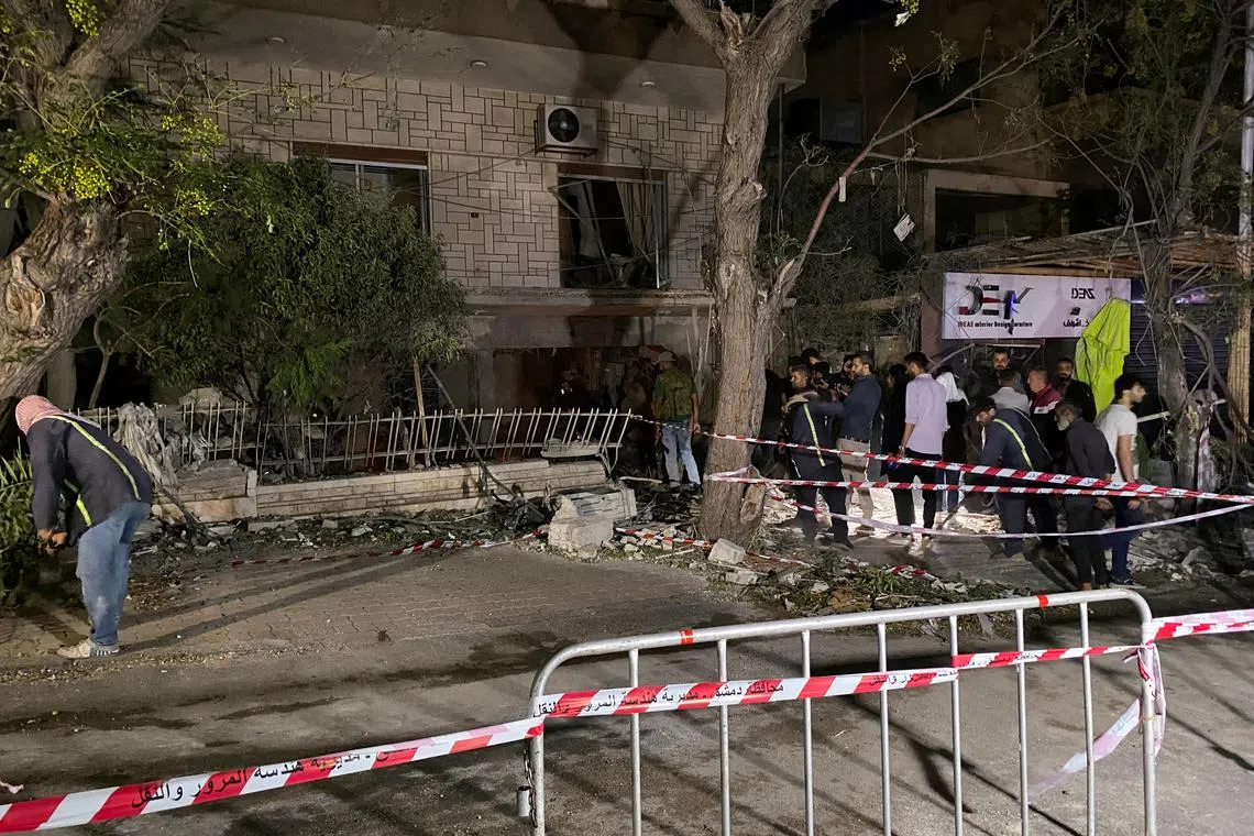 FILE PHOTO: People stand at the site of an Israeli airstrike that targeted a residential building in the Mezzah suburb in western Damascus, according to Syrian state media, Syria October 2, 2024. REUTERS/Firas Makdesi/File Photo