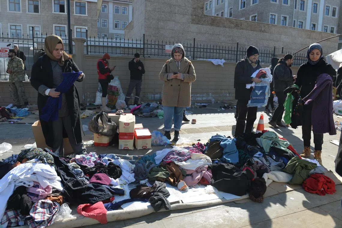 People gather to collect clothes and food at a makeshift aid point in Adiyaman, Turkey, on Feb 9, 2023.