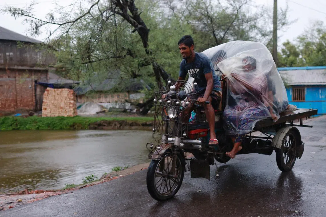 People move to a safe place before Cyclone Remal hits the country in the Shyamnagar area of Satkhira, Bangladesh, on May 26, 2024.