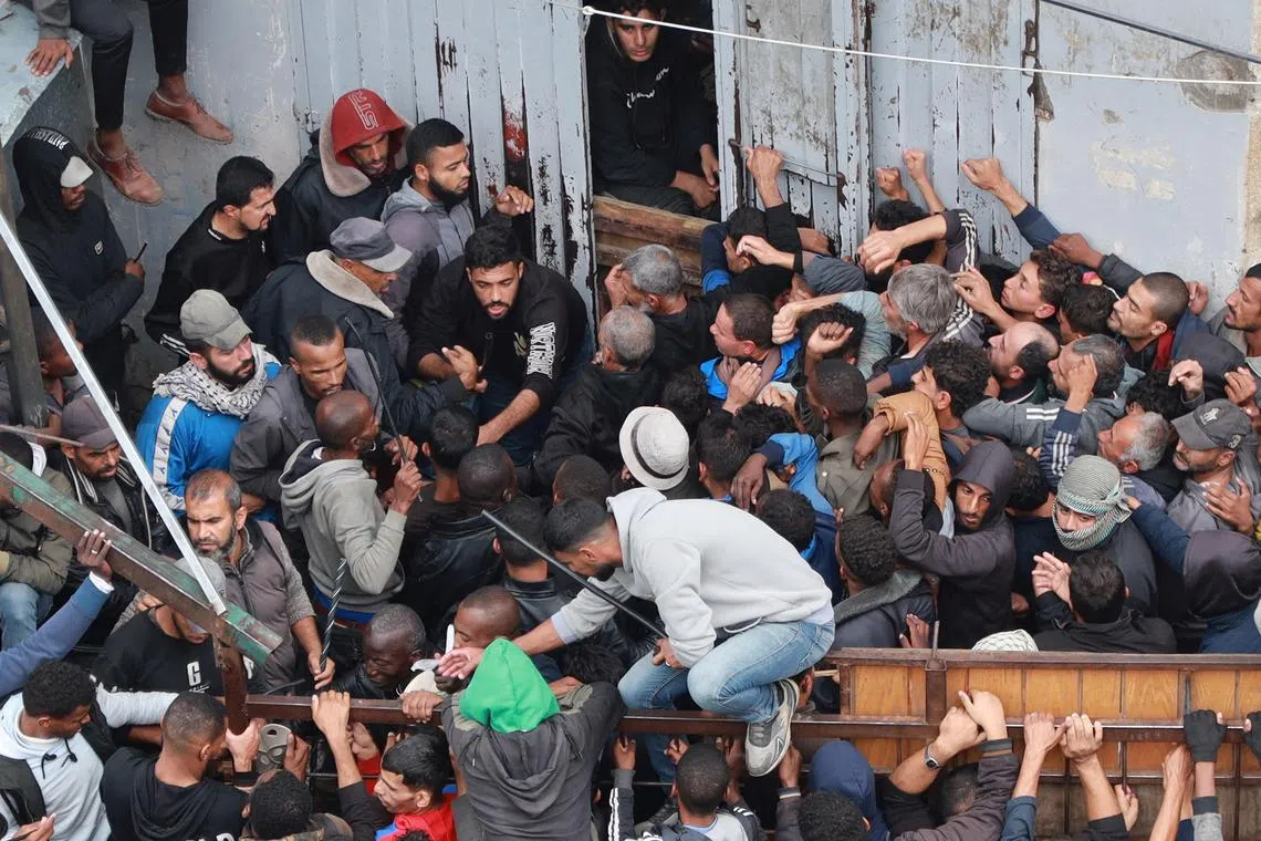 Palestinians waiting to receive bread from a bakery, in the central Gaza Strip, on Nov 29.