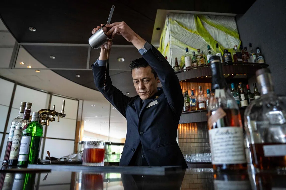 This picture taken on June 19 shows head bartender Shingo Miyachi pouring a Negroni cocktail into a glass with ice from Kuramoto Ice at a bar in the Hilton Narita in Narita, Chiba prefecture.