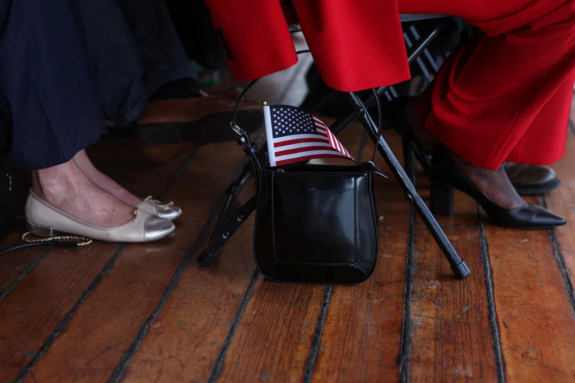 A US flag sticking out from the purse of a person attending a US citizenship and immigration services' naturalisation ceremony in New York City in 2023.  REUTERS/Shannon Stapleton