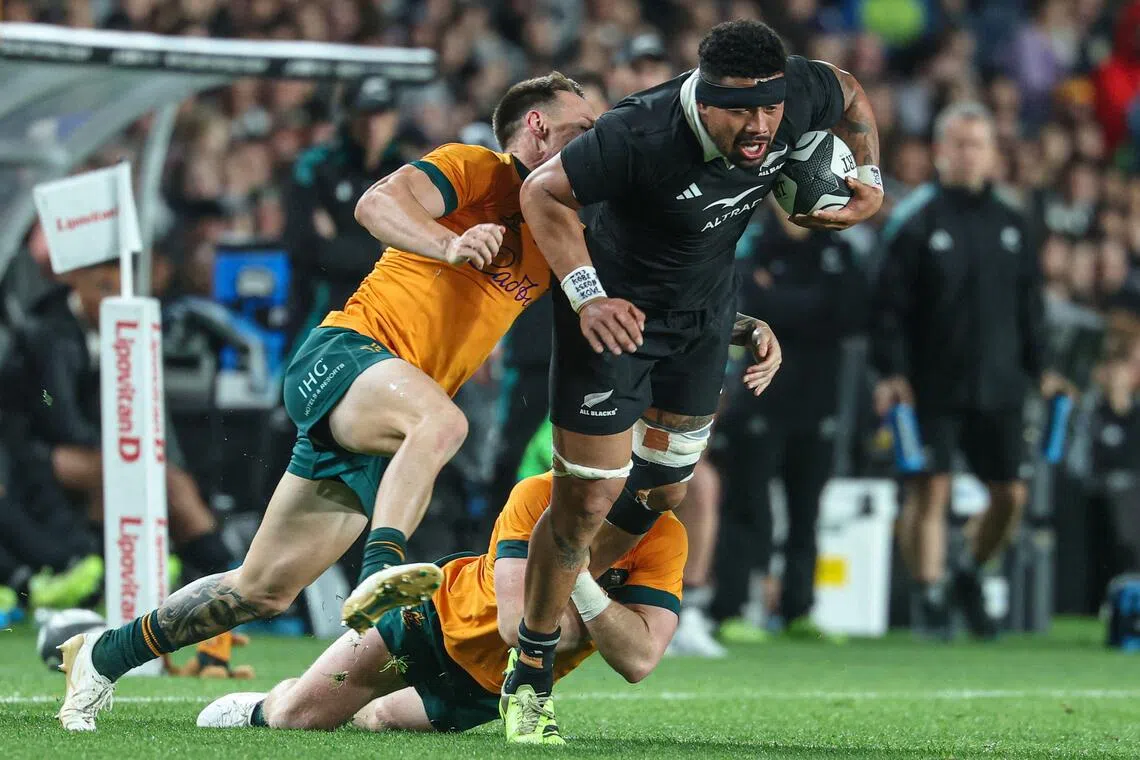 New Zealand's Ardie Savea is tackled by Australia's Billy Pollard in the Rugby Championship match at Eden Park in Auckland on Sept 27, 2025.