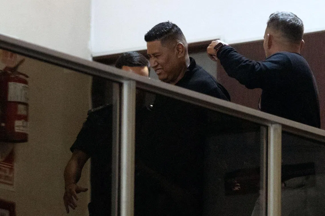 Bodyguard Julio Coria is escorted by police after being detained for false testimony at a court in San Isidro, in Argentina's Buenos Aires province, on March 25.