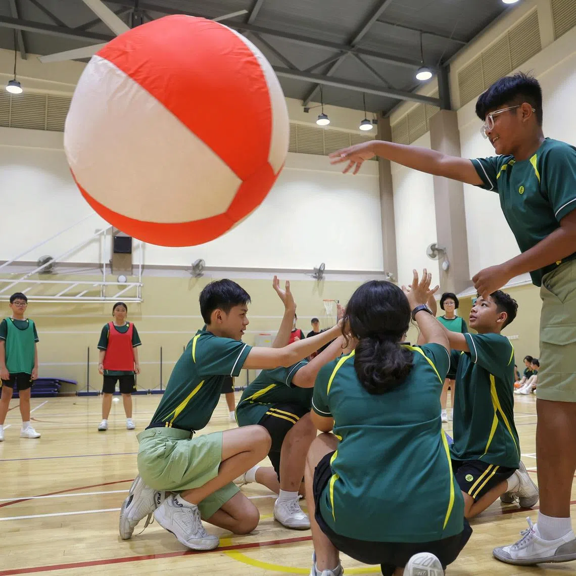 Secondary 1 students under Full Subject-Based Banding (Full SBB) Neo Kai Feng (left, kneeling), 12, and Noman Naushad (right, standing), 13, taking part in a team-building activity at Pasir Ris Secondary School on Jan 8, 2025.