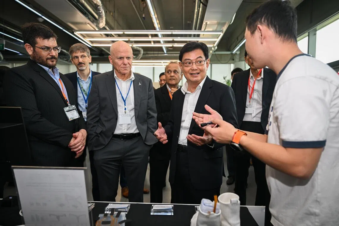 NRF chairman Heng Swee Keat touring a booth at the CREATE Symposium on June 25.