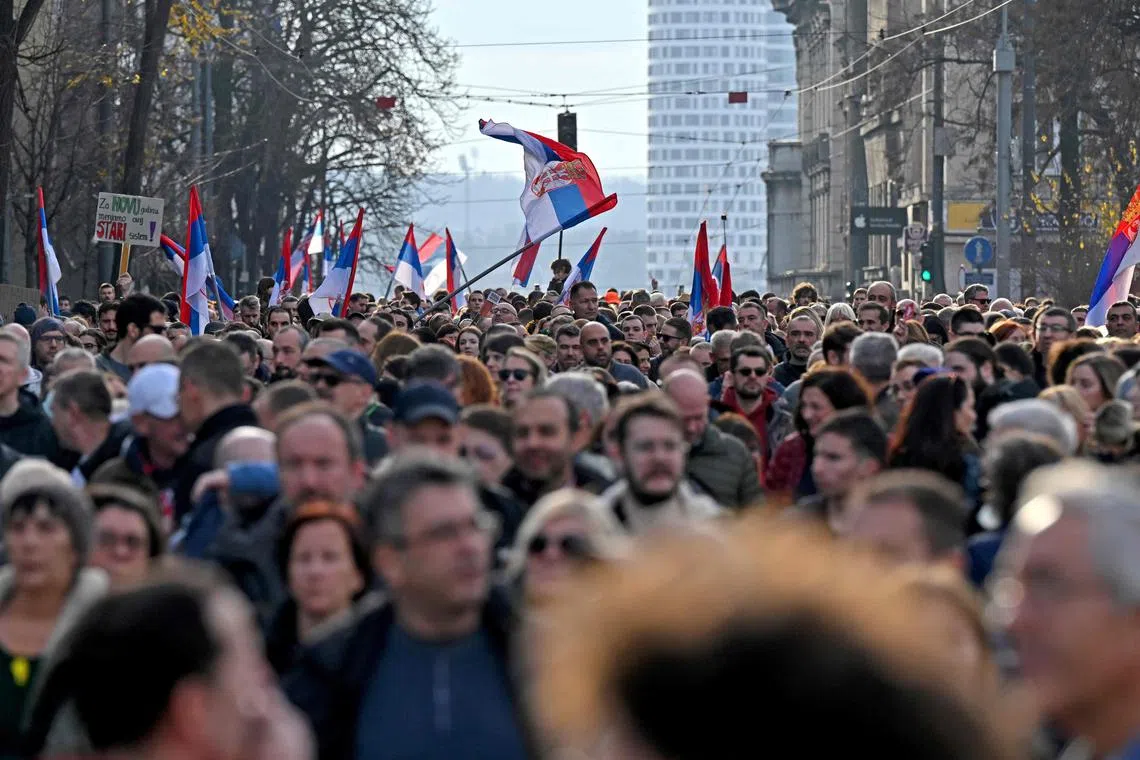 Protesters wave Serbian flags to protest against alleged electoral fraud, in Belgrade.