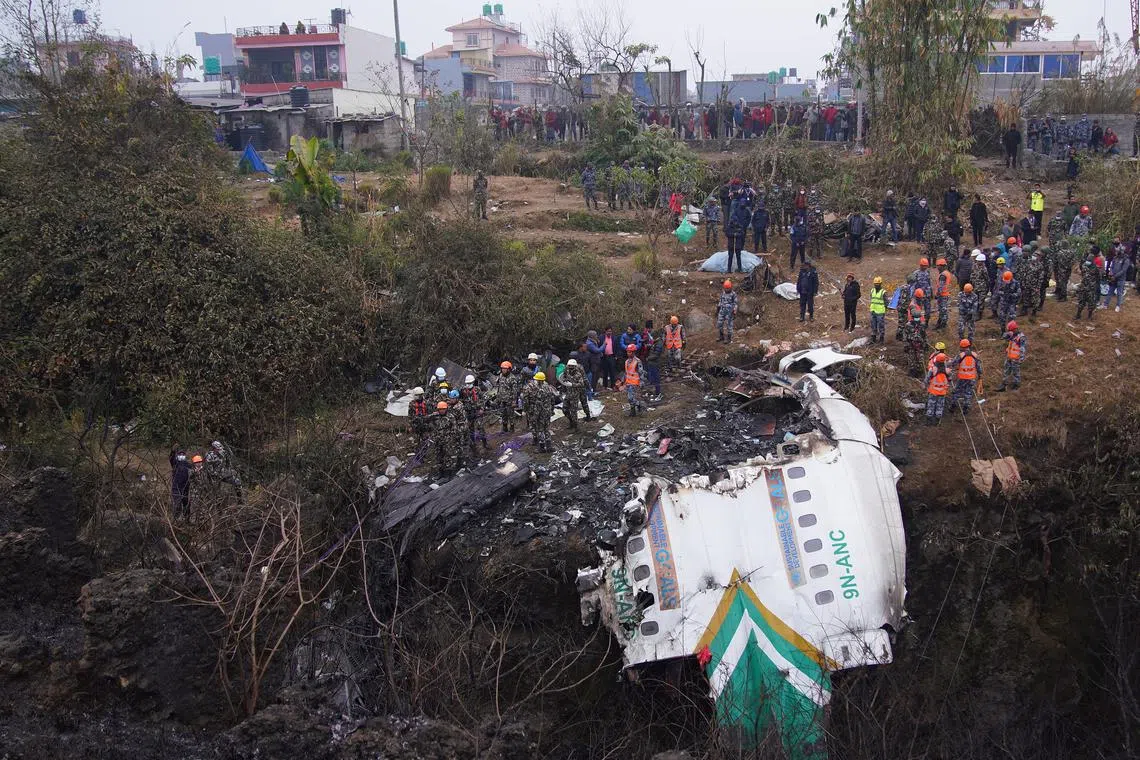 Rescue teams working near the wreckage at the crash site as they look for more bodies from a Yeti Airlines ATR72 aircraft in Pokhara, central Nepal, Jan 16, 2023. 