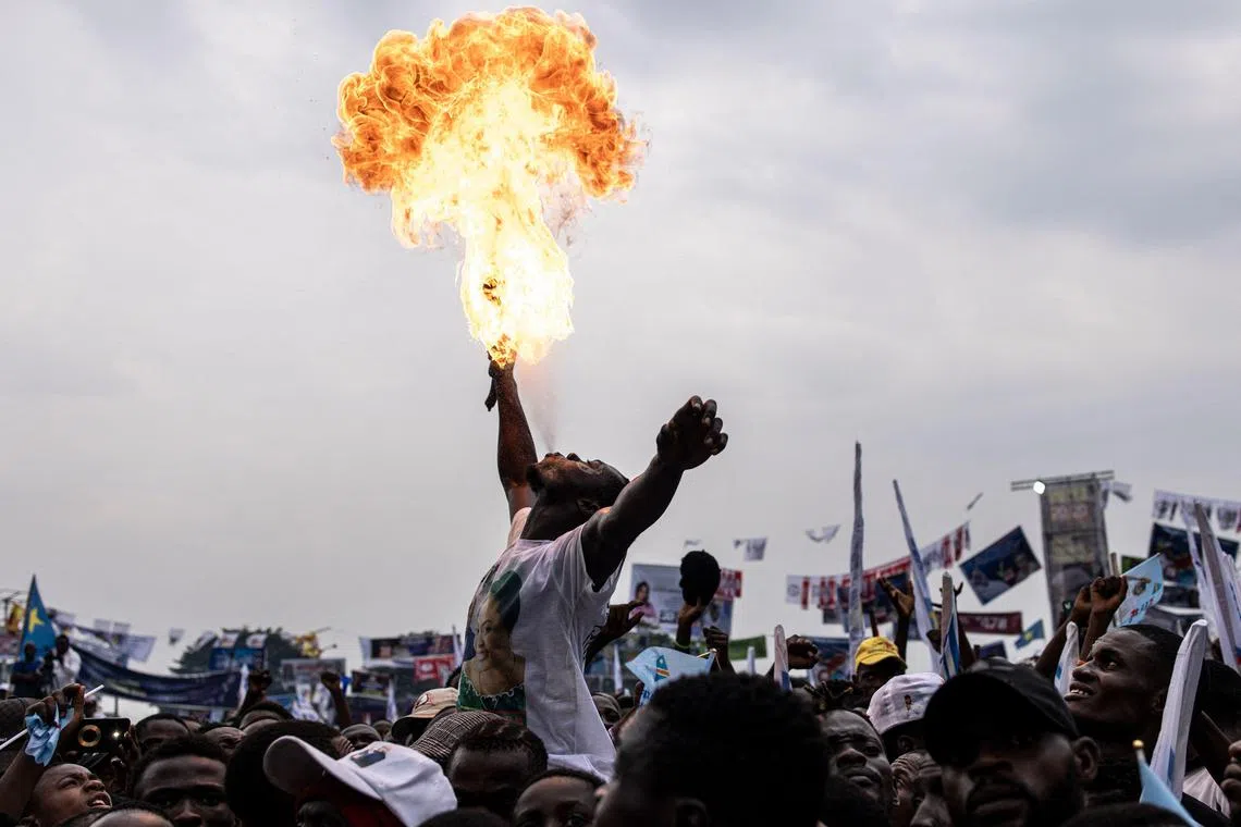 A supporter of President of the Democratic Republic of the Congo (DRC) and leader of the Union of Democracy and Social Progress (UDPS) party blowing fire at a campaign rally at Sainte Therese in the Ndjili district of Kinshasa on Dec 18. Forty-four million people are registered to vote in the presidential, parliamentary, provincial and municipal elections scheduled for Dec 20.