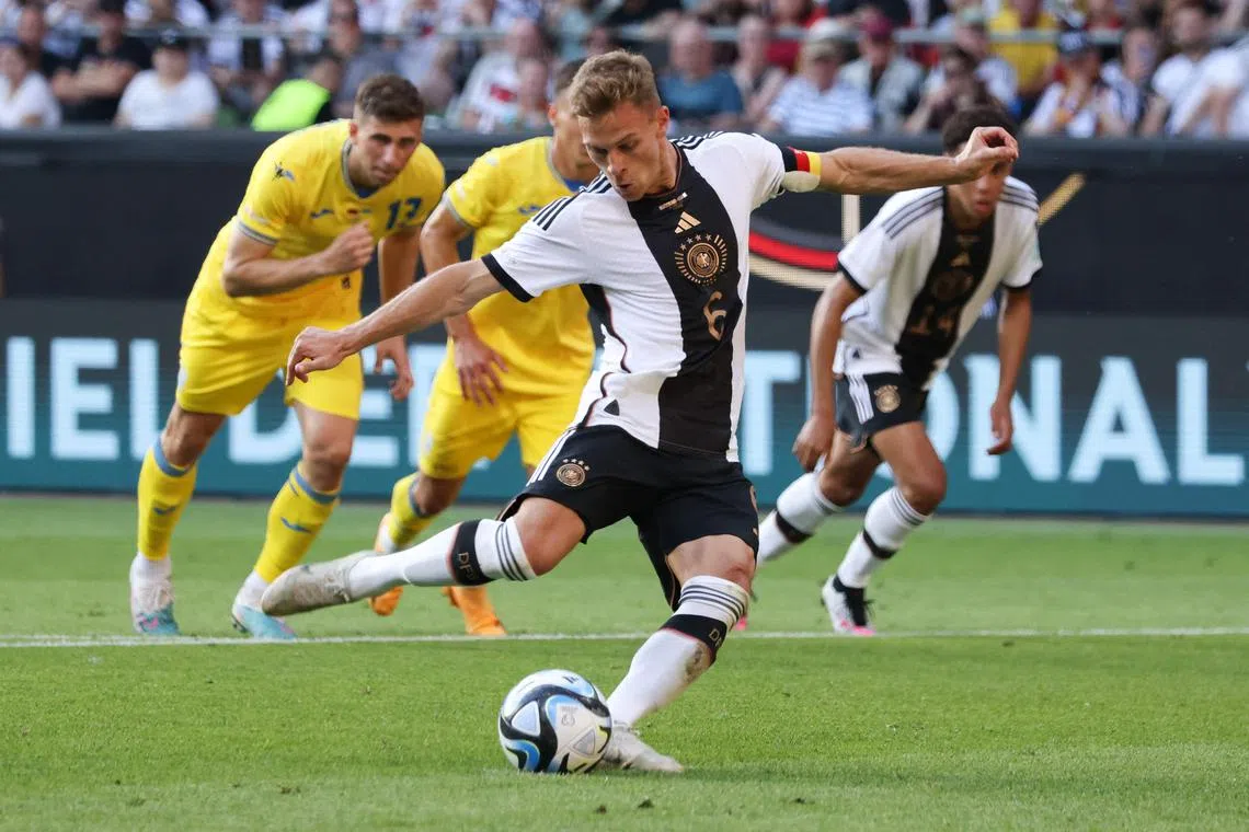Germany's midfielder Joshua Kimmich prepares to kick the ball in a penalty shootout to score the 3-3 goal.